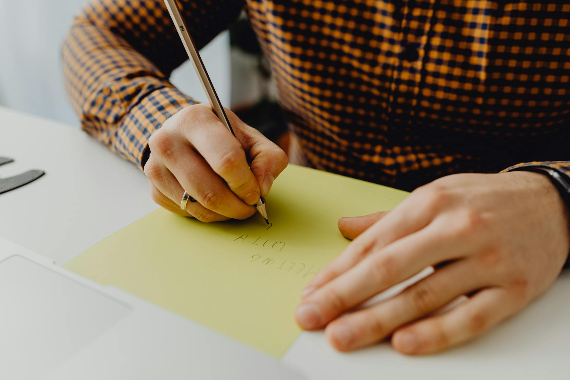 Dłoń z długopisem zapisuje żółtą kartkę z planem przerw ruchowych