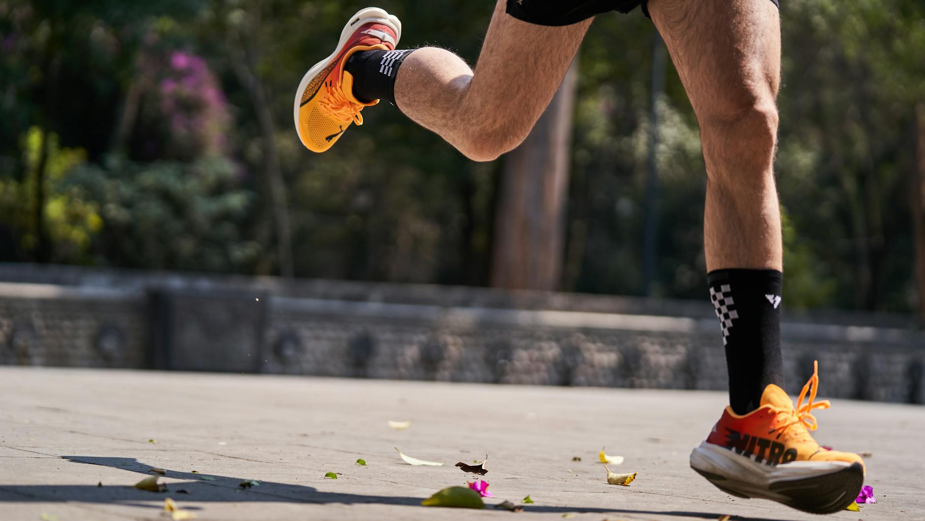 Biegacz w pomarańczowych butach podczas dynamicznego biegu na dworze