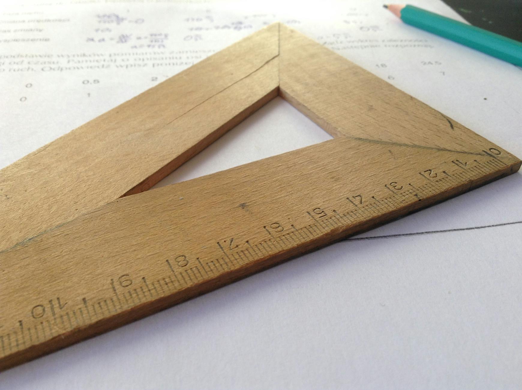 Drewniana linijka leżąca na kartce papieru podczas nauki matematyki