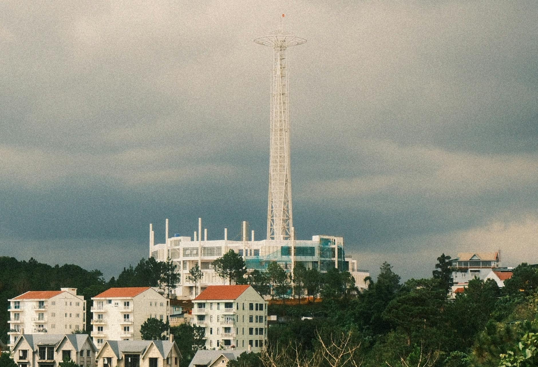 Wysoki wieżowiec wśród nowoczesnych budynków miasta pod burzowym niebem