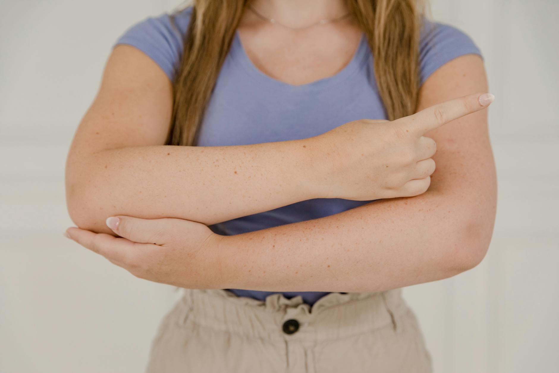 Kobieta w pomieszczeniu pokazuje dłonie, gestykulując rękami