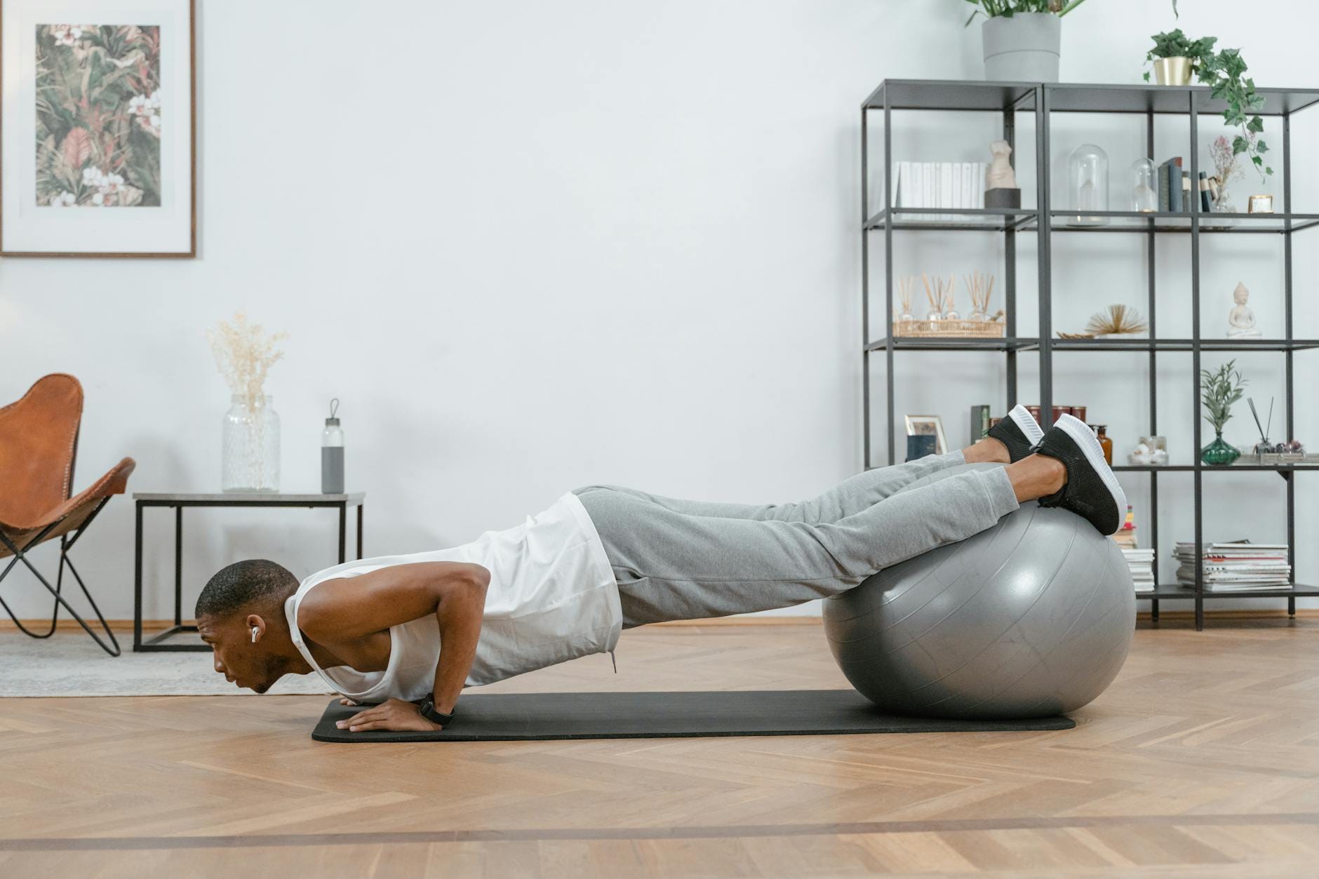 Mężczyzna robi pompki z nogami na piłce fitness w domu