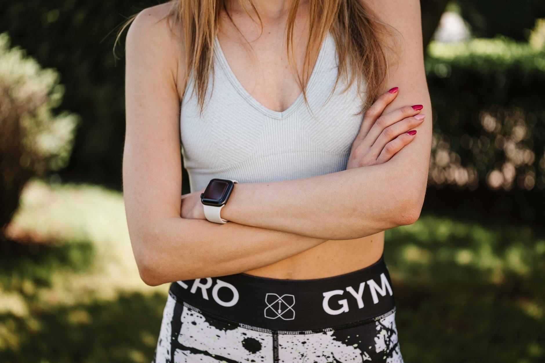 Pewna siebie kobieta w staniku sportowym i legginsach, pozuje na zewnątrz