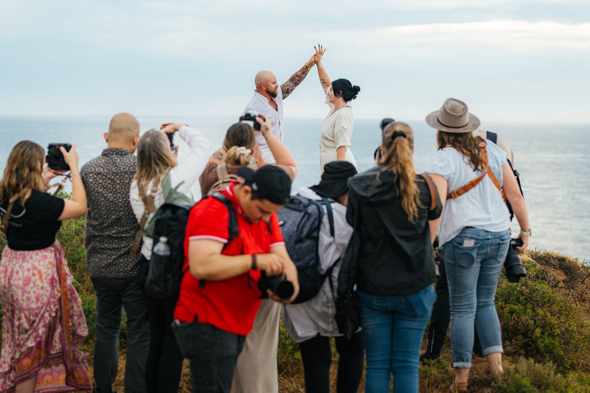 Para młoda pozująca nad morzem podczas sesji ślubnej z fotografami