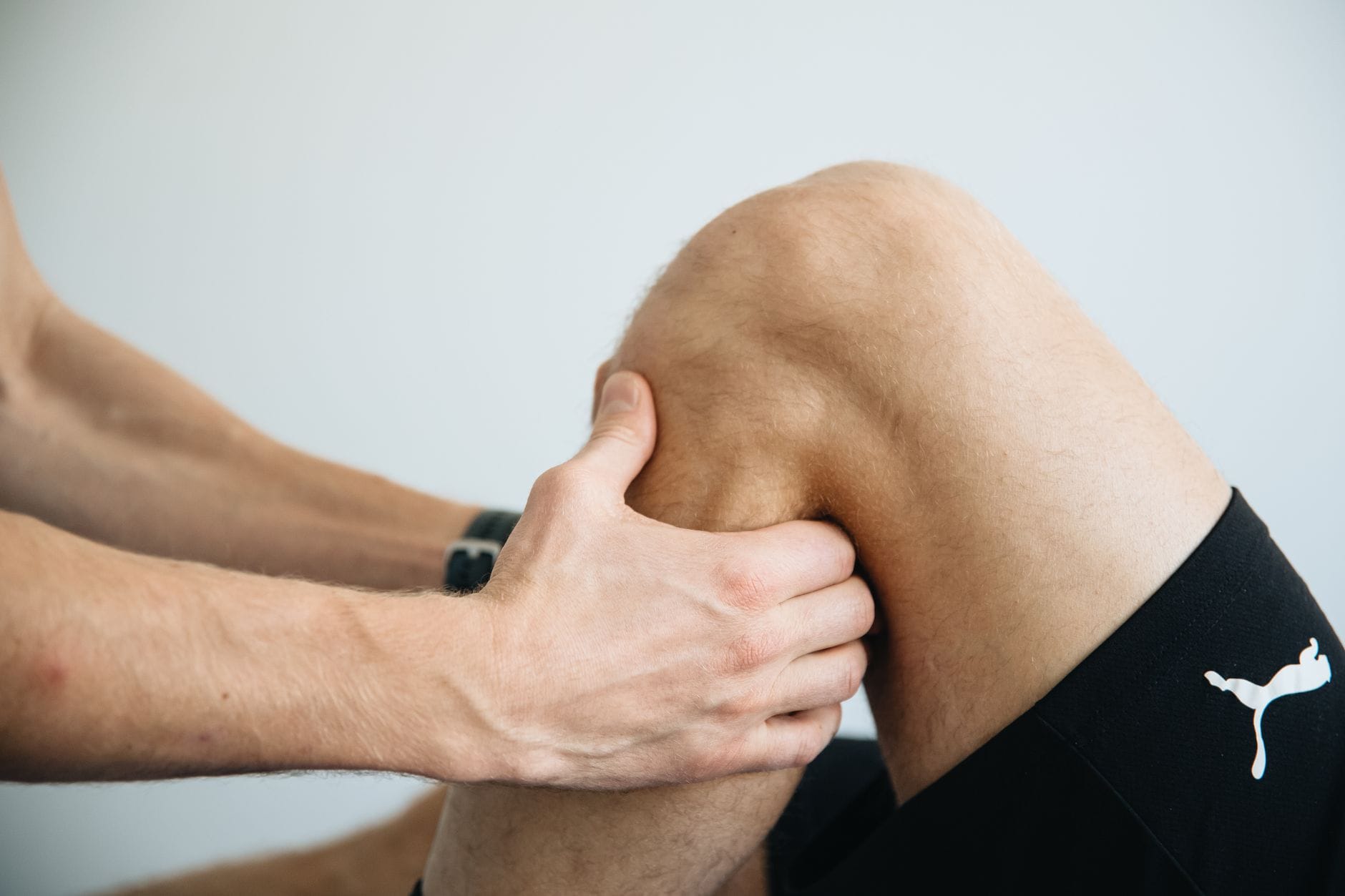 Fizjoterapeuta wykonuje masaż kolana po rekonstrukcji ACL